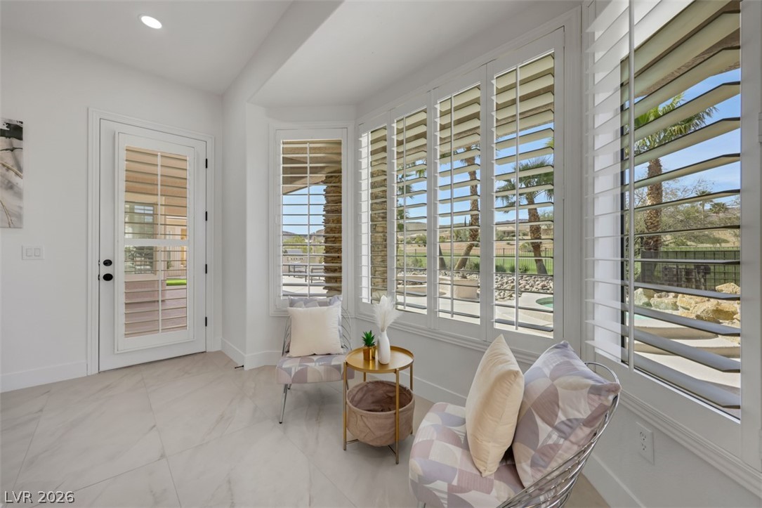 5015 Rivedro Street Las Vegas, NV 89135 - Photo 45 of 91 A well-lit interior space features elegant plantation shutters offering serene views of the outdoors.