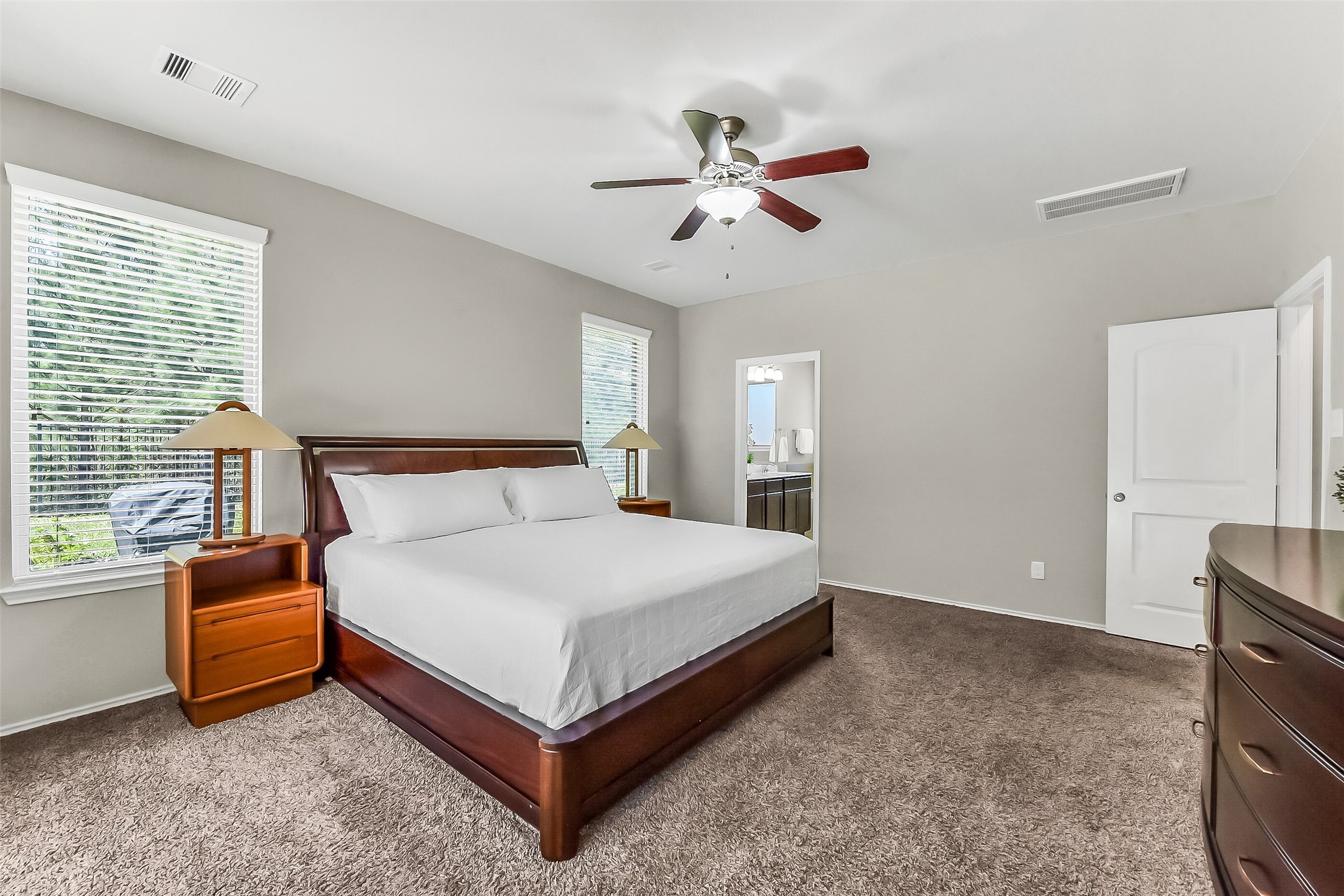 24407 Hollow Gate Meadow Court Spring, TX 77389 - Photo 19 of 39 a spacious bedroom with a bed and a chandelier