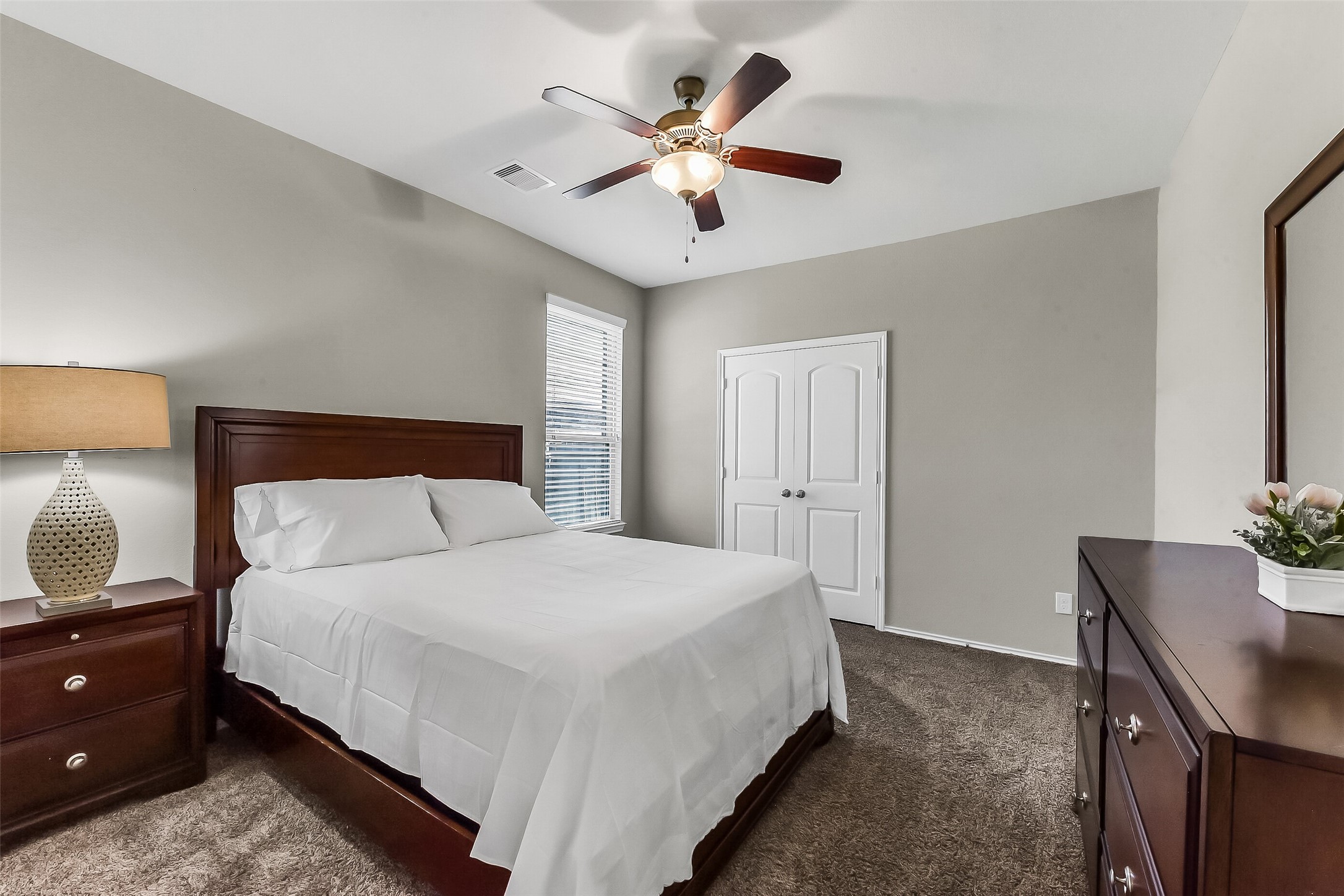 24407 Hollow Gate Meadow Court Spring, TX 77389 - Photo 22 of 39 a bedroom with a bed and a chandelier