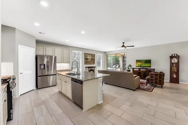 a kitchen with stainless steel appliances granite countertop a sink stove microwave and refrigerator