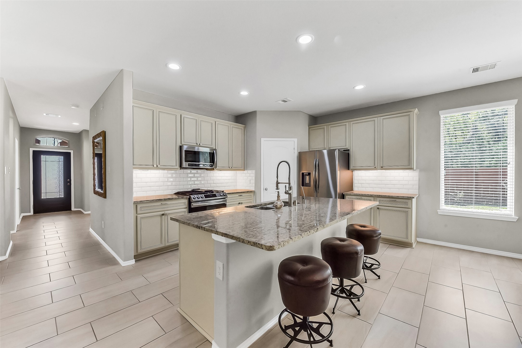 24407 Hollow Gate Meadow Court Spring, TX 77389 - Photo 6 of 39 a kitchen with refrigerator and chairs