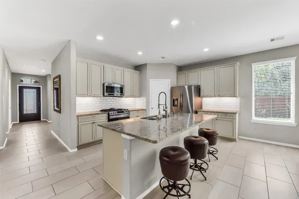 a kitchen with granite countertop a sink stove and cabinets