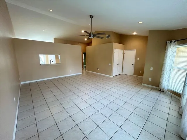 an empty room with windows and fan