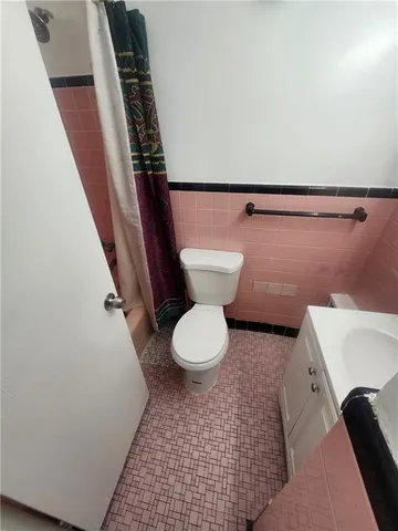 a bathroom with a toilet and a mirror