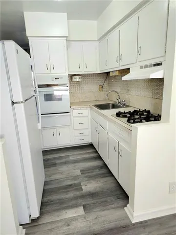 a kitchen with white cabinets and white appliances