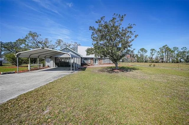 a view of a house with a yard and sitting area