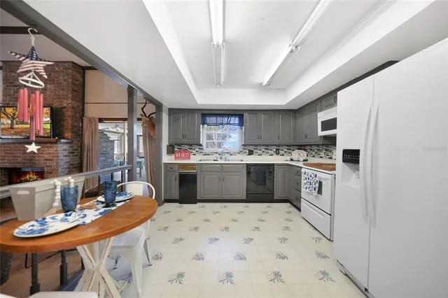 a kitchen with stainless steel appliances kitchen island granite countertop a sink a stove a refrigerator cabinets a dining table and chairs