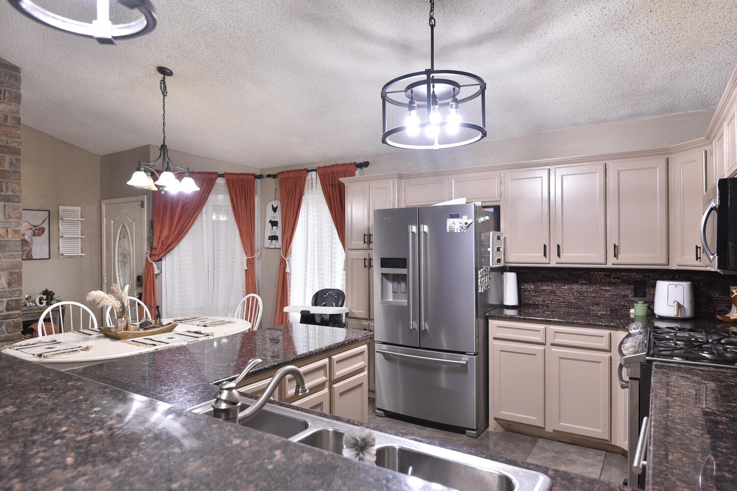 5202 93rd Street Lubbock, TX 79424 - Photo 13 of 28 a kitchen with stainless steel appliances granite countertop a sink refrigerator and microwave