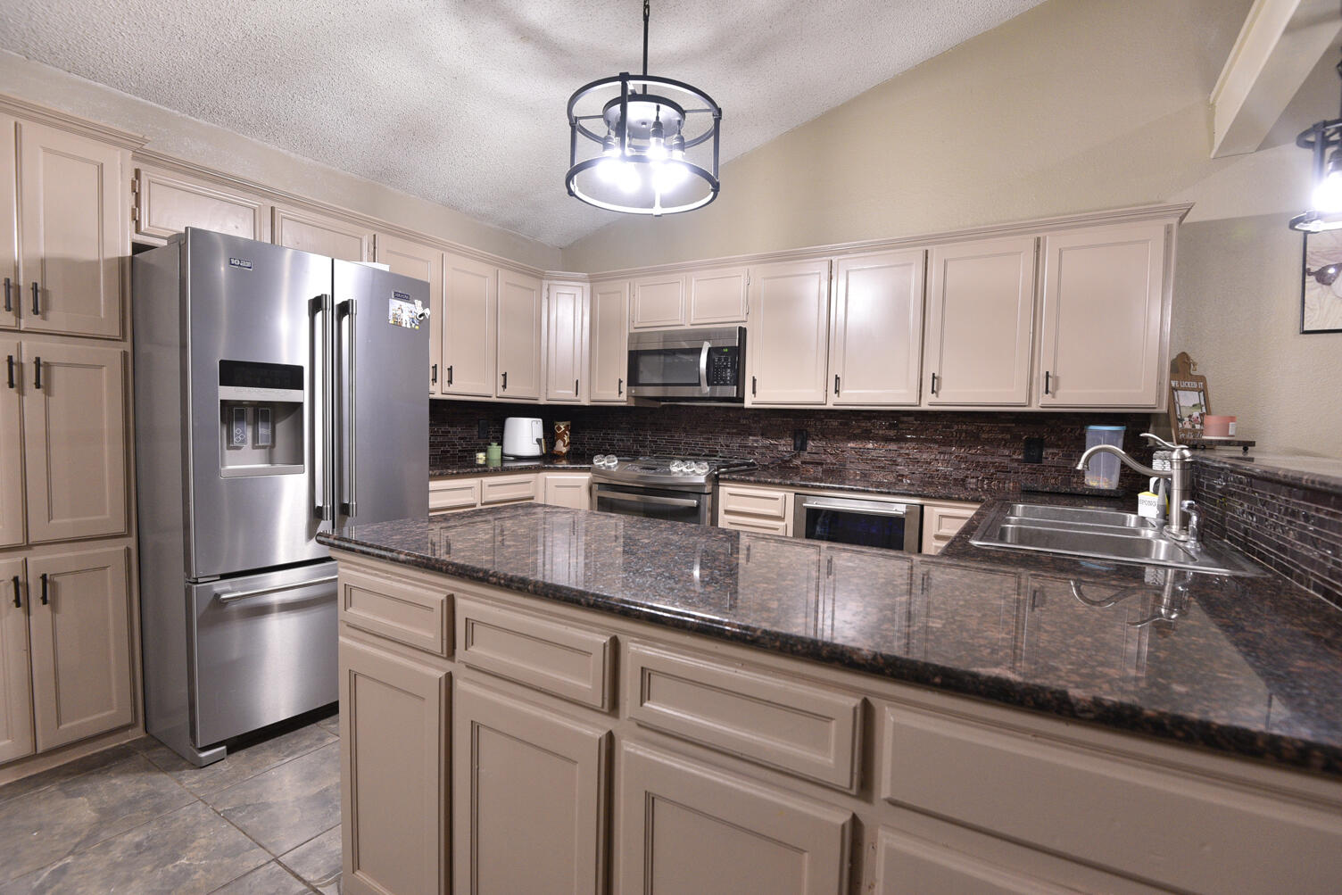5202 93rd Street Lubbock, TX 79424 - Photo 9 of 28 a kitchen with stainless steel appliances granite countertop a refrigerator a stove a sink and a refrigerator