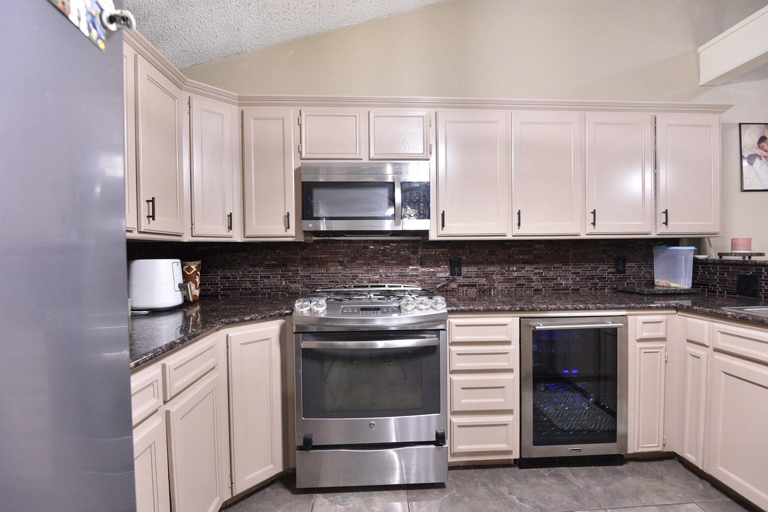 5202 93rd Street Lubbock, TX 79424 - Photo 10 of 28 a kitchen with granite countertop white cabinets and stainless steel appliances
