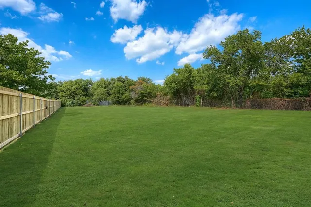 a view of a green field with wooden fence
