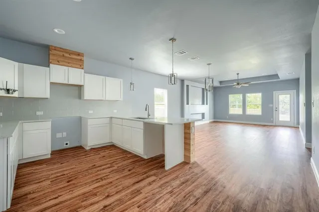 a view of a kitchen with wooden floor and a window