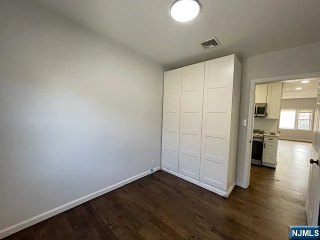 a view of empty room with wooden floor