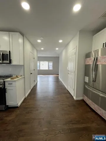 a view of a refrigerator in kitchen and wooden floor