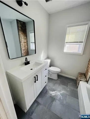 a bathroom with a double vanity sink and a toilet