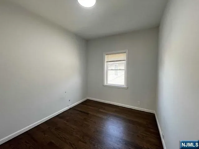 an empty room with wooden floor and window