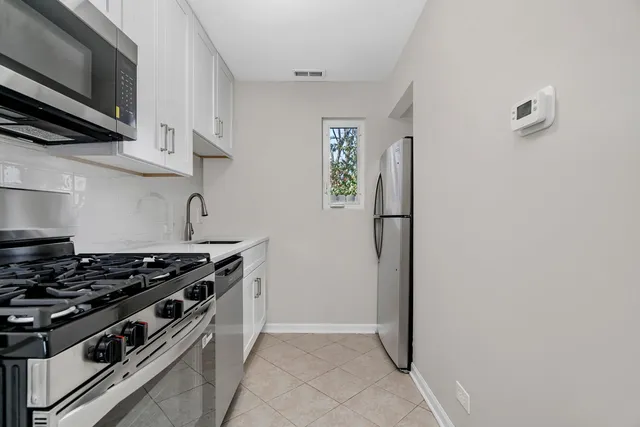 a kitchen with stainless steel appliances granite countertop a stove and a refrigerator