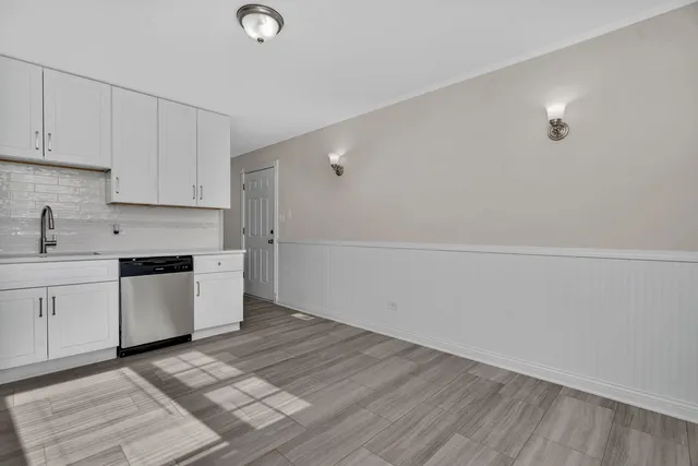a kitchen with cabinets and wooden floor