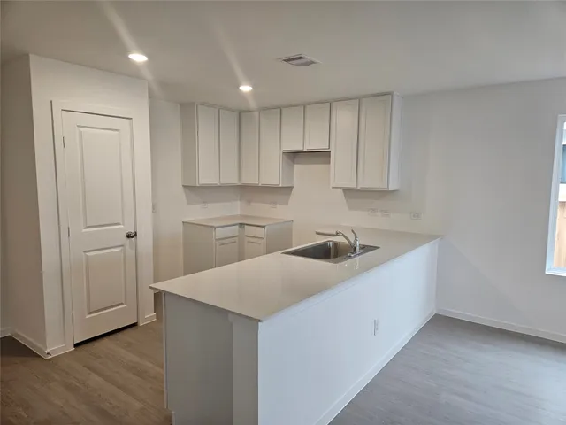 a kitchen with kitchen island white cabinets and stainless steel appliances