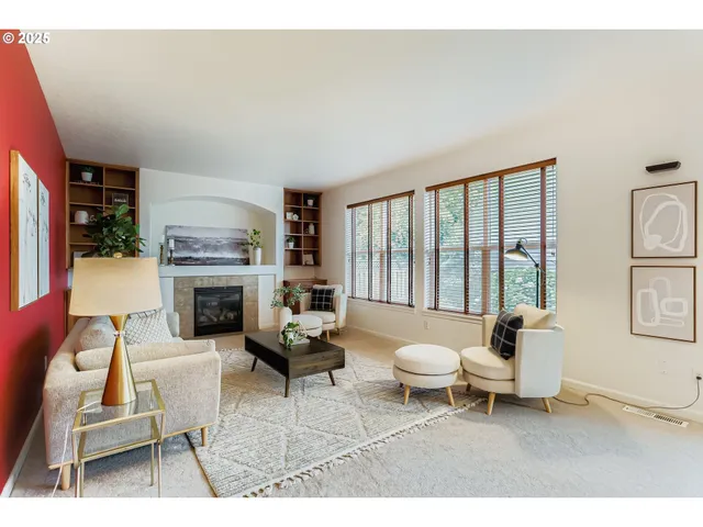 a living room with furniture a fireplace and a large window