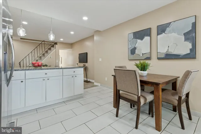 a kitchen with stainless steel appliances kitchen island granite countertop a refrigerator a stove a microwave oven a sink with a dining table and chairs