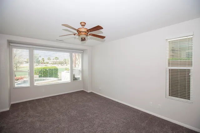 a view of a livingroom with a ceiling fan and window