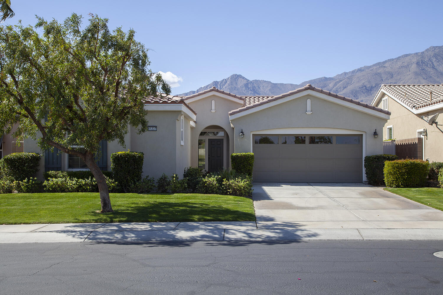 81237 Red Rock Road La Quinta, CA 92253 - Photo 3 of 21 a front view of a house with a yard and garage
