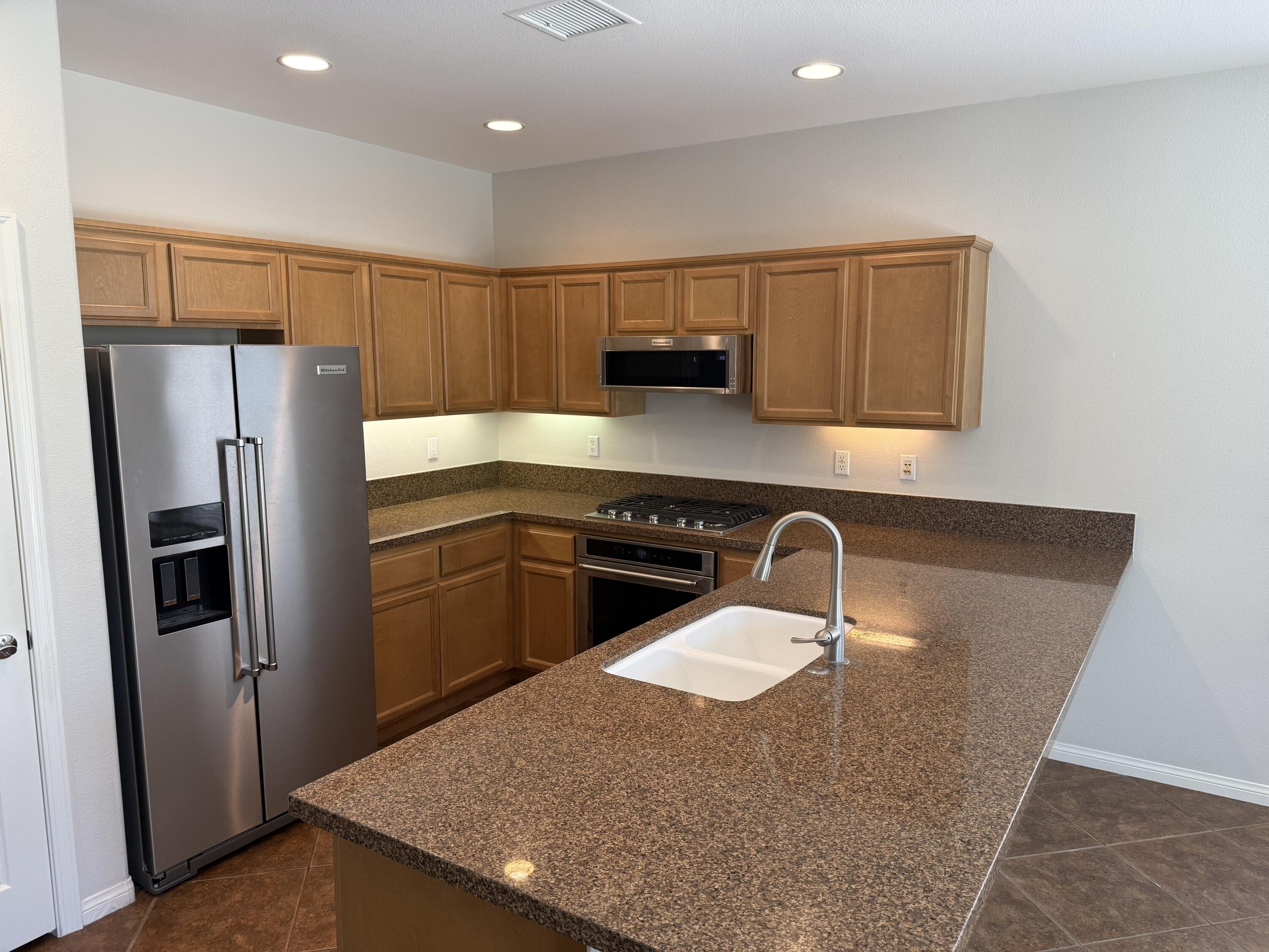 81237 Red Rock Road La Quinta, CA 92253 - Photo 7 of 21 a kitchen with stainless steel appliances granite countertop a refrigerator a sink a stove a microwave a counter top and oven