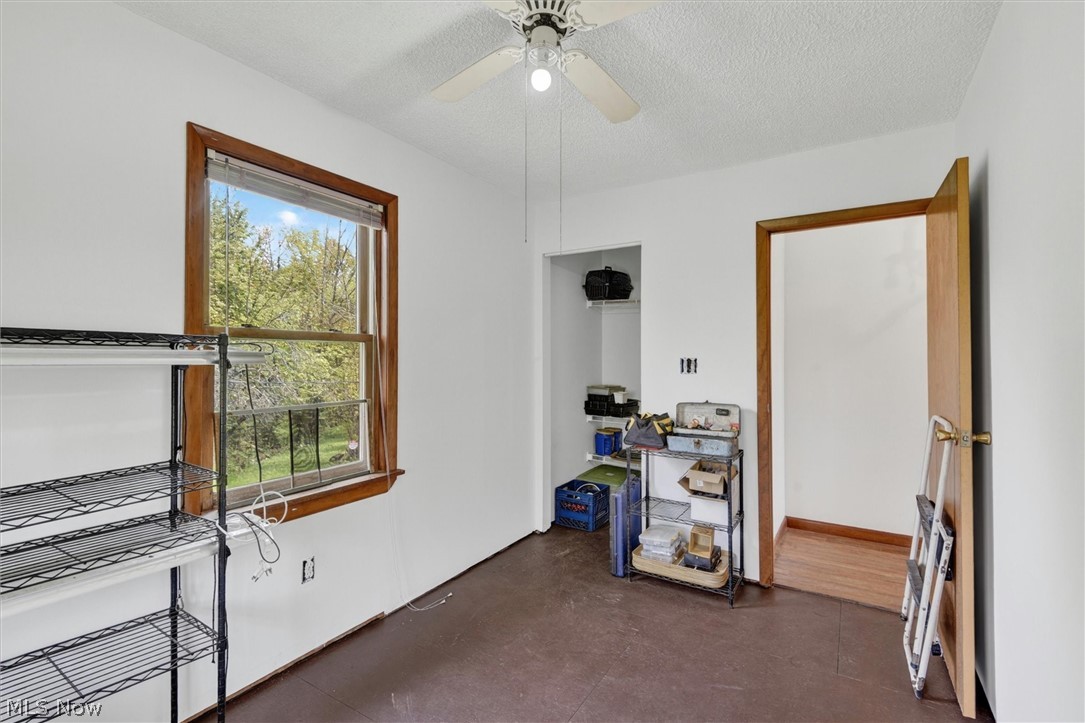 1526 Stevenson Road Ashtabula, OH 44004 - Photo 20 of 50 Room featuring a window with natural wood trim, white walls, and a ceiling fan with integrated lighting