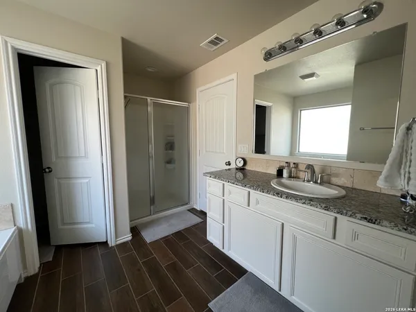 a bathroom with a granite countertop sink and a mirror