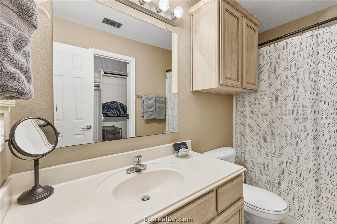 1001 Krenek Tap Road, Unit 1306 College Station, TX 77840 - Photo 17 of 22 a bathroom with a toilet a sink and a mirror