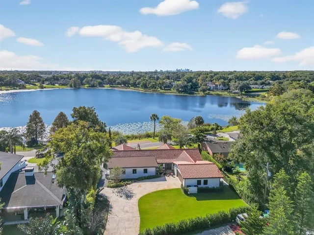 an aerial view of a house with a garden and lake view