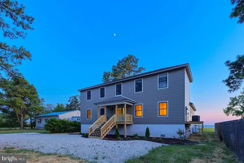 a kitchen with stainless steel appliances granite countertop a stove a sink and a refrigerator with wooden floors