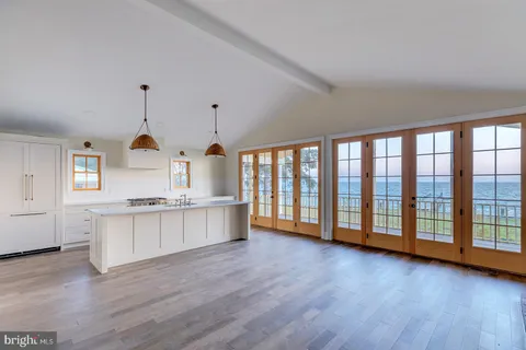 a kitchen with a sink a chandelier and wooden floor