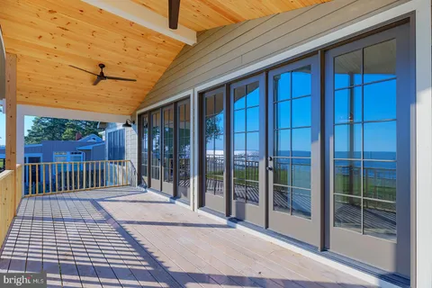 a view of an empty room with wooden floor fireplace and a window