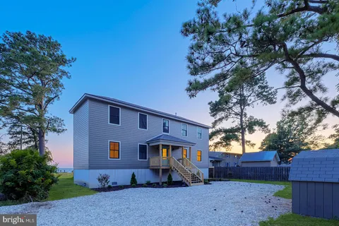 a view of empty room with wooden floor and fireplace