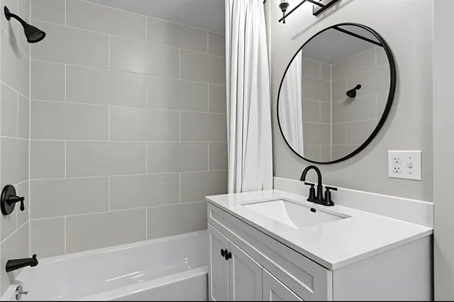 a bathroom with a sink and mirror with bathtub