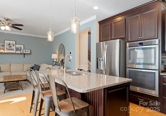 a kitchen with stainless steel appliances granite countertop a kitchen island a table and chairs