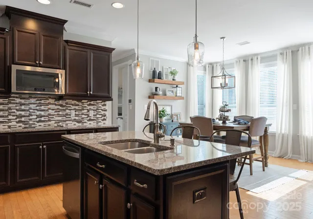 a kitchen with granite countertop a sink appliances and cabinets