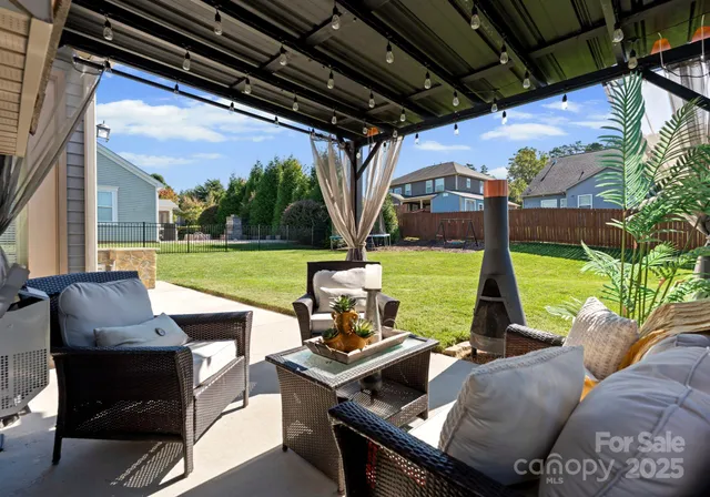 a view of a patio with couches chairs and a big yard