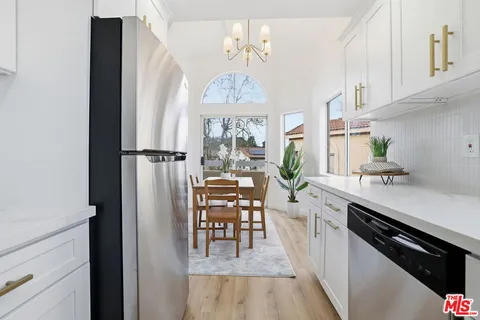 a kitchen with stainless steel appliances a dining table chairs and chandelier