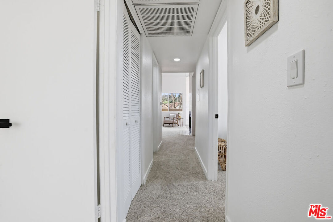 19834 Sandpiper Place, Unit 64 Newhall, CA 91321 - Photo 22 of 40 a view of a hallway with paintings on the walls