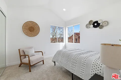 a bedroom with a bed and painting on the wall
