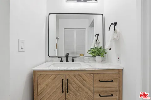 a bathroom with a granite countertop sink and a mirror