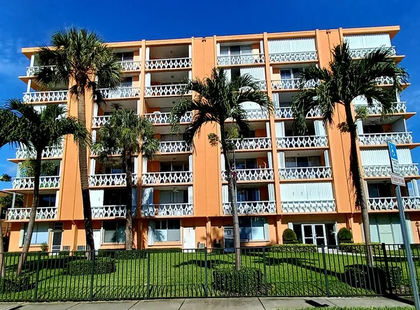 a front view of multi story residential apartment building with a yard