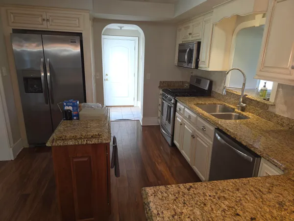 a kitchen with stainless steel appliances granite countertop a sink stove and refrigerator