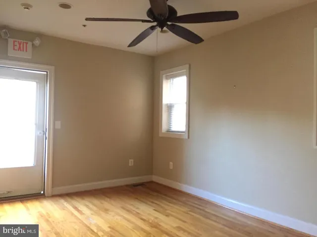 a view of an empty room with wooden floor & closet