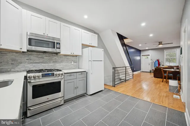 a kitchen with stainless steel appliances granite countertop a stove a microwave and a refrigerator