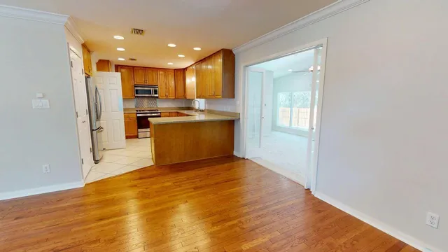 a view of empty room with wooden floor and fan