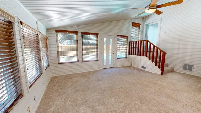 a view of empty room with window and wooden floor